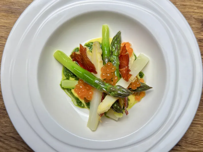 Het opgemaakte bord: Asperge salade/ aji amarillo kaas saus/hollandse pesto/ serranoham/ zalm eitjes