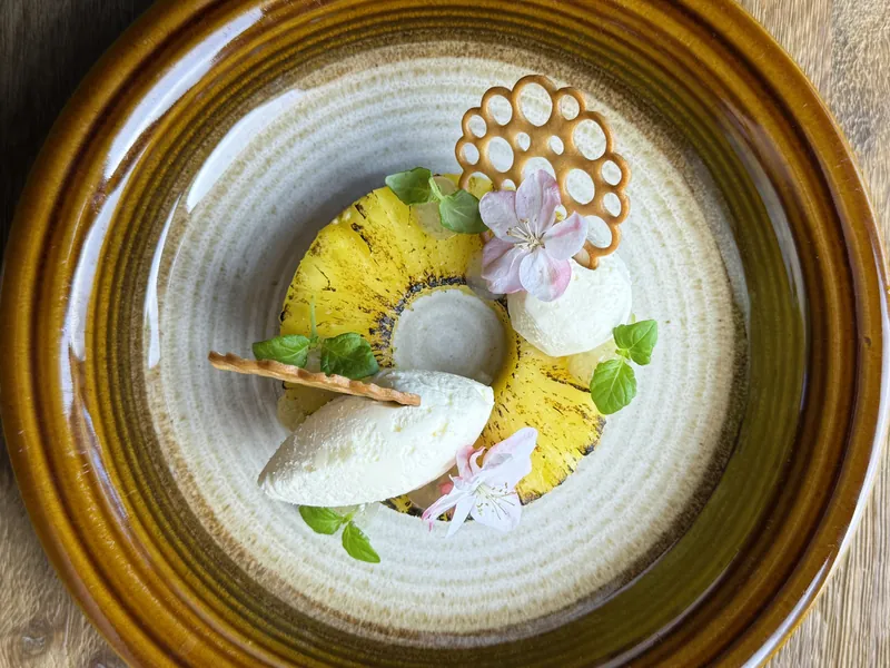 Het opgemaakte bord: Ananas in rum/ limoen mousse/ mojito gel/ honing tuille/ bloesem